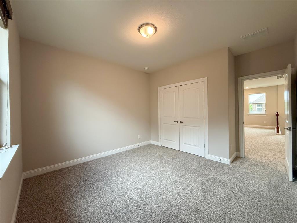 9829 Sharps Road Frisco, TX 75035 - Photo 29 of 40 Unfurnished bedroom with light colored carpet and a closet