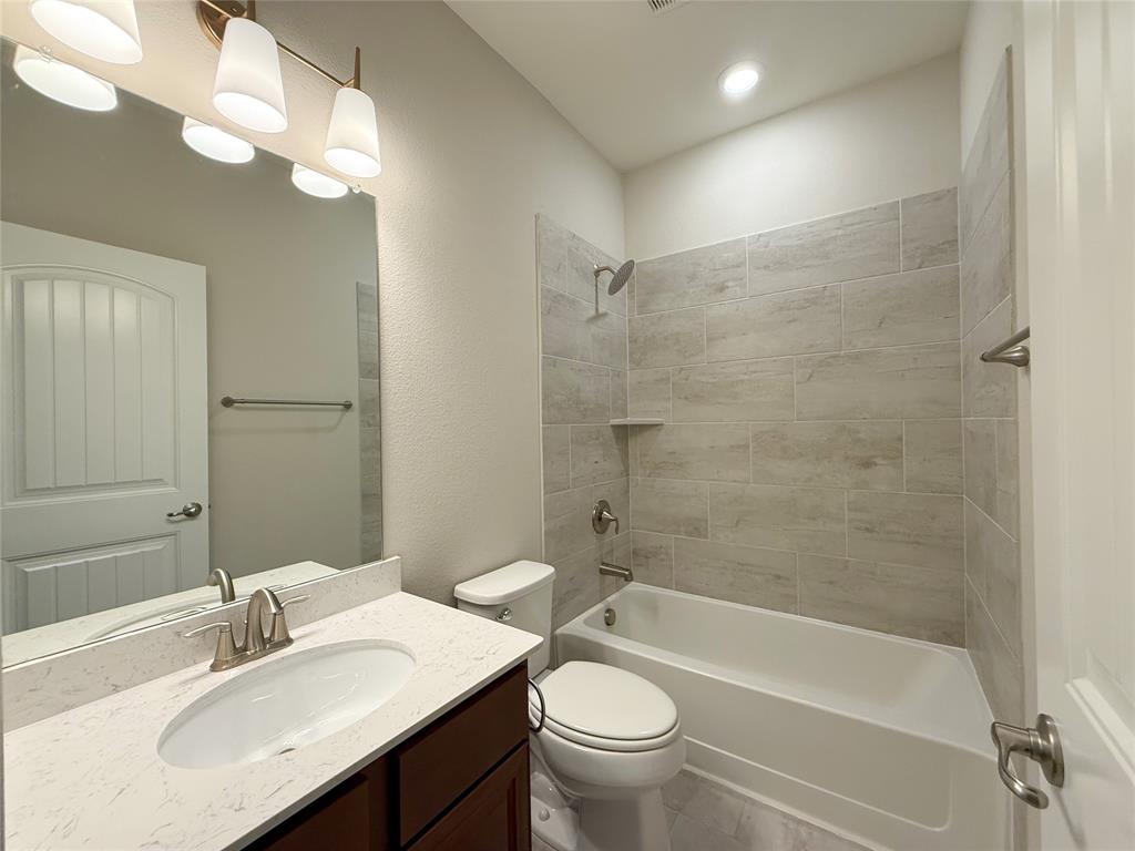 9829 Sharps Road Frisco, TX 75035 - Photo 35 of 40 Full bath with vanity, shower / bathtub combination, and a textured wall