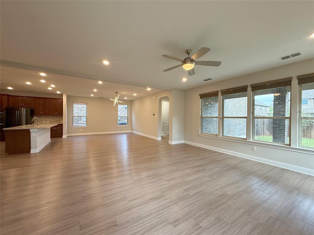 9829 Sharps Road Frisco, TX 75035 - Photo 9 of 40 Unfurnished living room featuring a ceiling fan, light wood-type flooring, recessed lighting, and arched walkways
