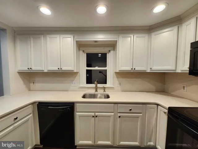 a kitchen with white cabinets and a sink