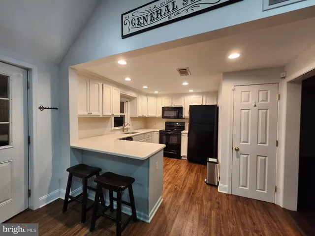 a kitchen with stainless steel appliances a sink cabinets and wooden floor