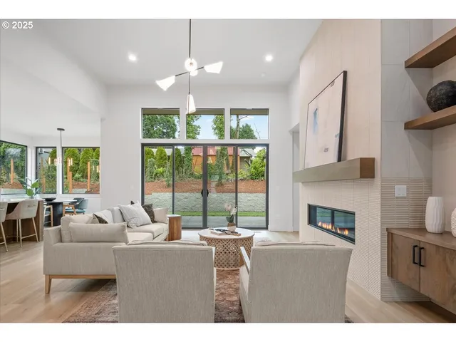 a living room with furniture a fireplace and a floor to ceiling window