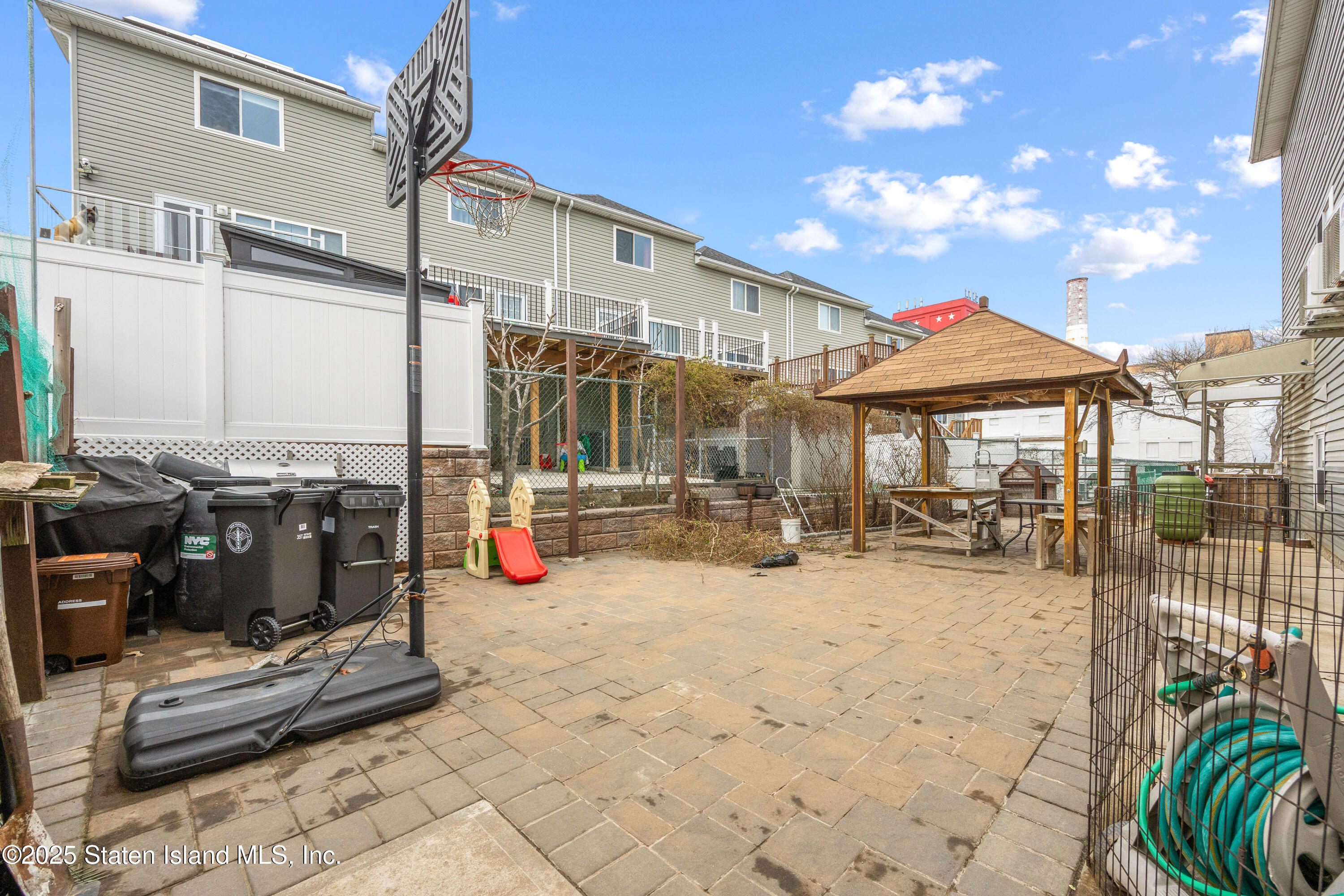 41 Burgundy Loop Staten Island, NY 10304 - Photo 22 of 29 a view of a patio with a table and chairs under an umbrella