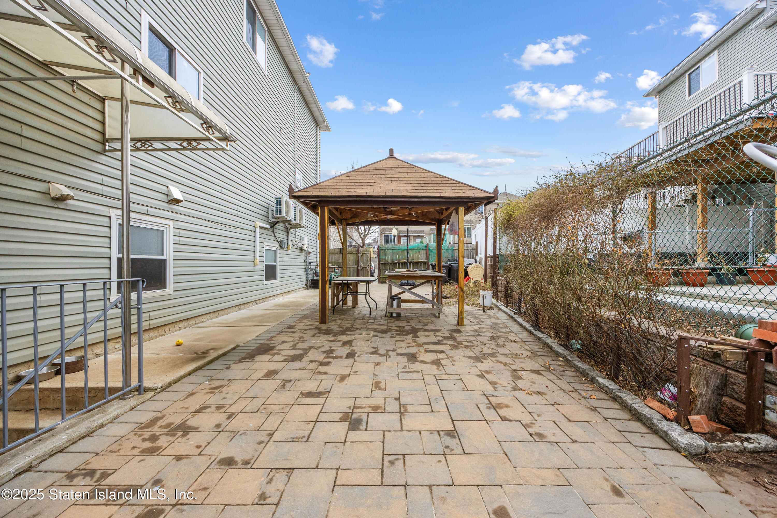 41 Burgundy Loop Staten Island, NY 10304 - Photo 23 of 29 a view of a patio with table and chairs with wooden floor and fence