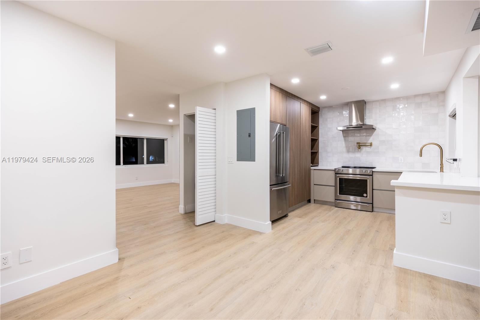 6070 Southwest 42nd Street Miami, FL 33155 - Photo 11 of 40 a kitchen with stainless steel appliances kitchen island granite countertop a refrigerator and a sink