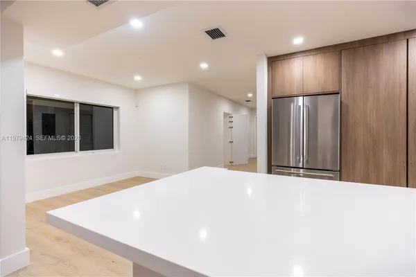 a view of an empty room with wooden cabinet