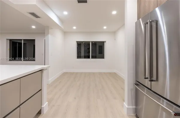 a view of an empty room with a window and wooden floor