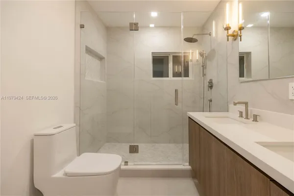 a bathroom with a shower sink and mirror