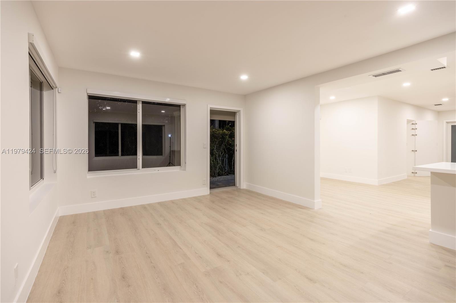 6070 Southwest 42nd Street Miami, FL 33155 - Photo 20 of 40 a view of an empty room with wooden floor and windows