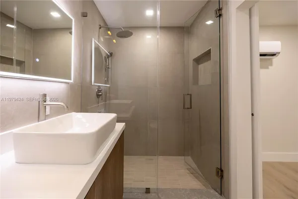 a bathroom with a sink a mirror and a shower