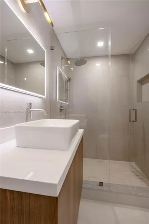 a bathroom with a sink a mirror and shower