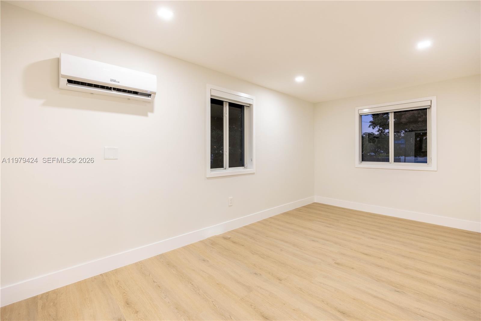 6070 Southwest 42nd Street Miami, FL 33155 - Photo 25 of 40 an empty room with wooden floor and windows