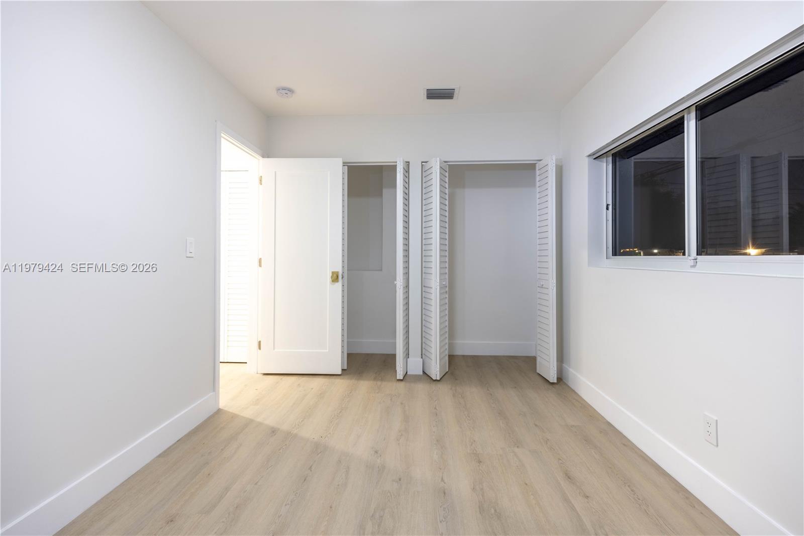 6070 Southwest 42nd Street Miami, FL 33155 - Photo 27 of 40 an empty room with wooden floor and windows