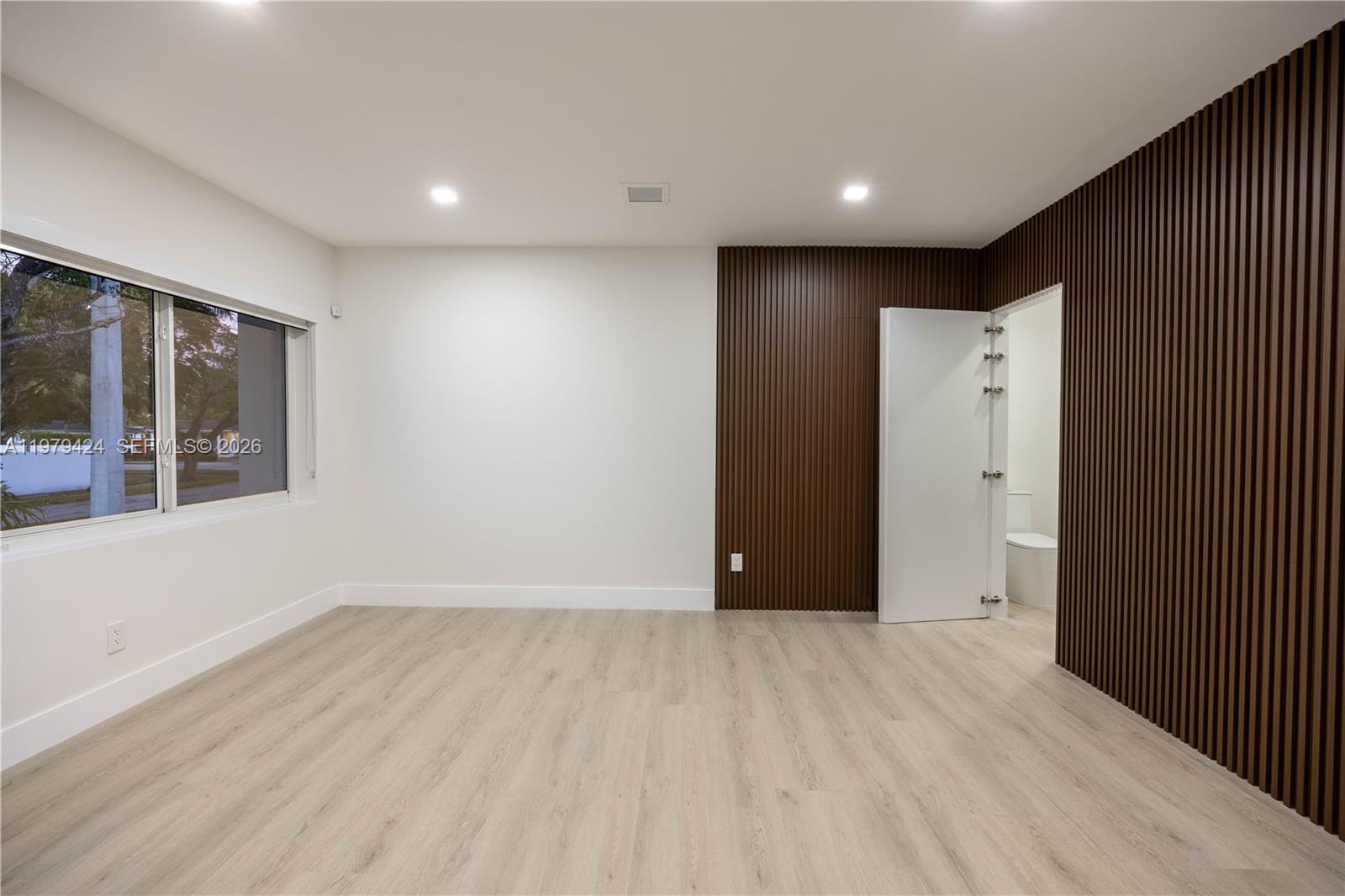 6070 Southwest 42nd Street Miami, FL 33155 - Photo 8 of 40 a view of an empty room with wooden floor and a window