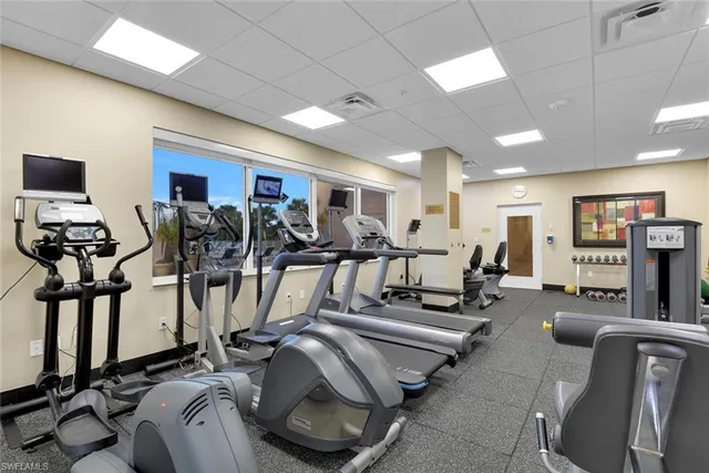 a living room with lots of gym equipment and a large mirror