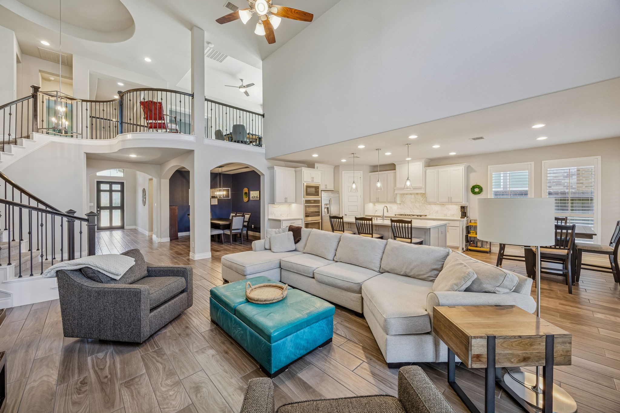 28706 Casen Ranch Lane Fulshear, TX 77441 - Photo 7 of 31 Designed for seamless entertaining, the large family area opens directly to the gourmet kitchen and formal dining space, highlighted by an elegant wrought-iron staircase.
