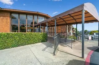 a patio with a table and chairs and potted plants