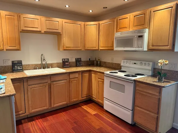 a kitchen with stainless steel appliances granite countertop a sink stove and cabinets