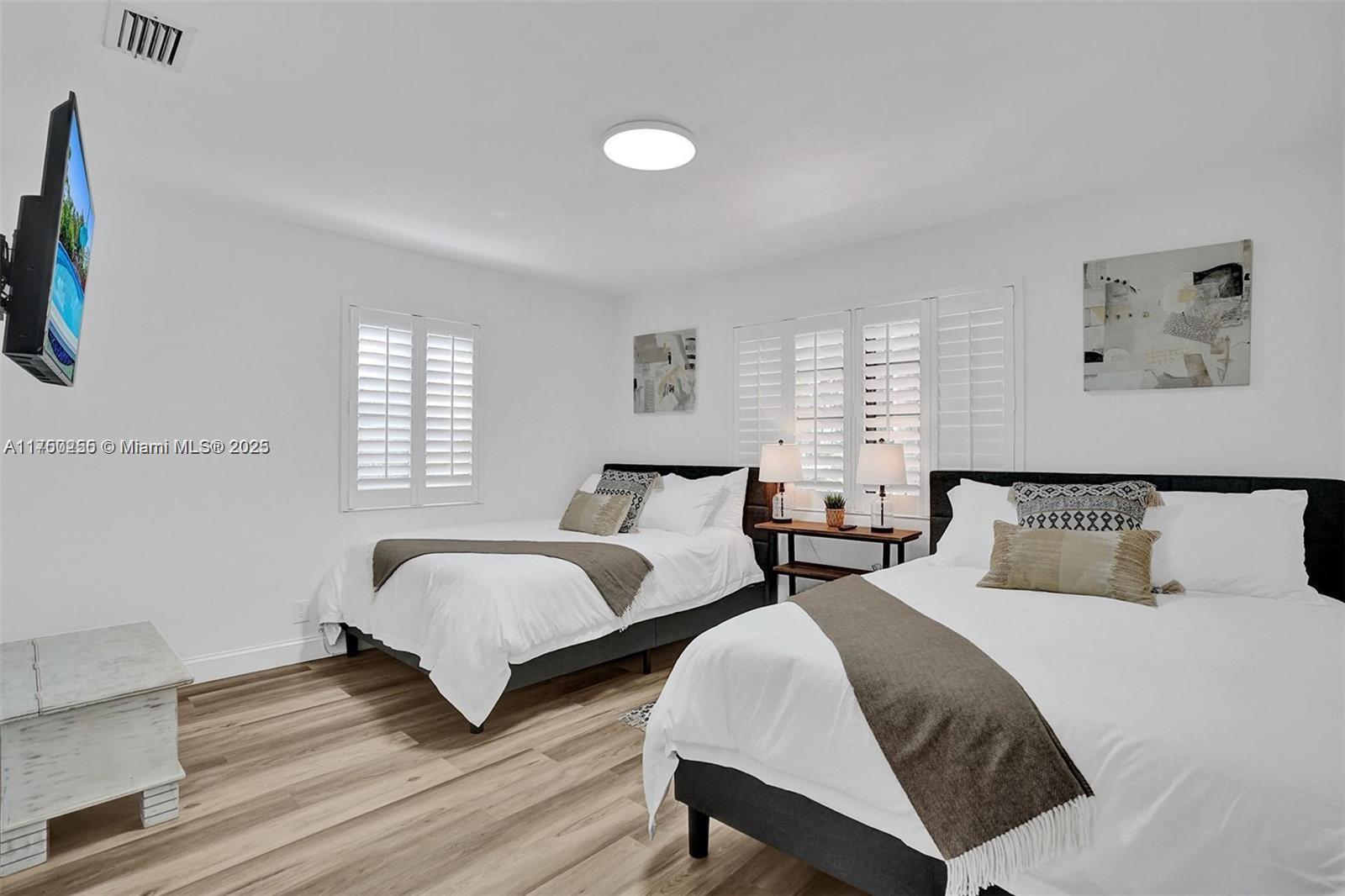 110 Southwest 5th Street Hallandale Beach, FL 33009 - Photo 13 of 26 a spacious bedroom with two beds and a window