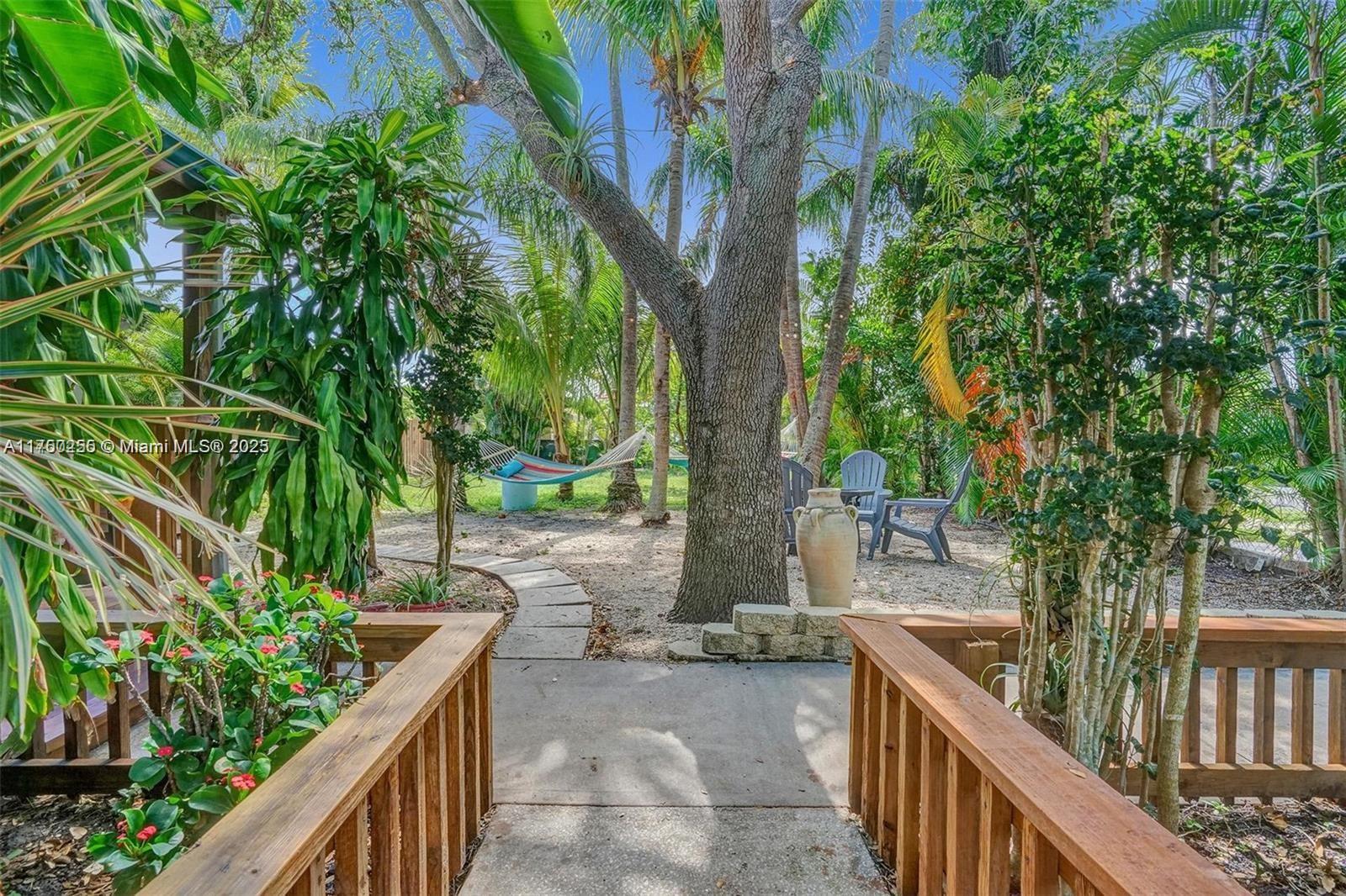 110 Southwest 5th Street Hallandale Beach, FL 33009 - Photo 18 of 26 a view of a pathway of a house with large trees