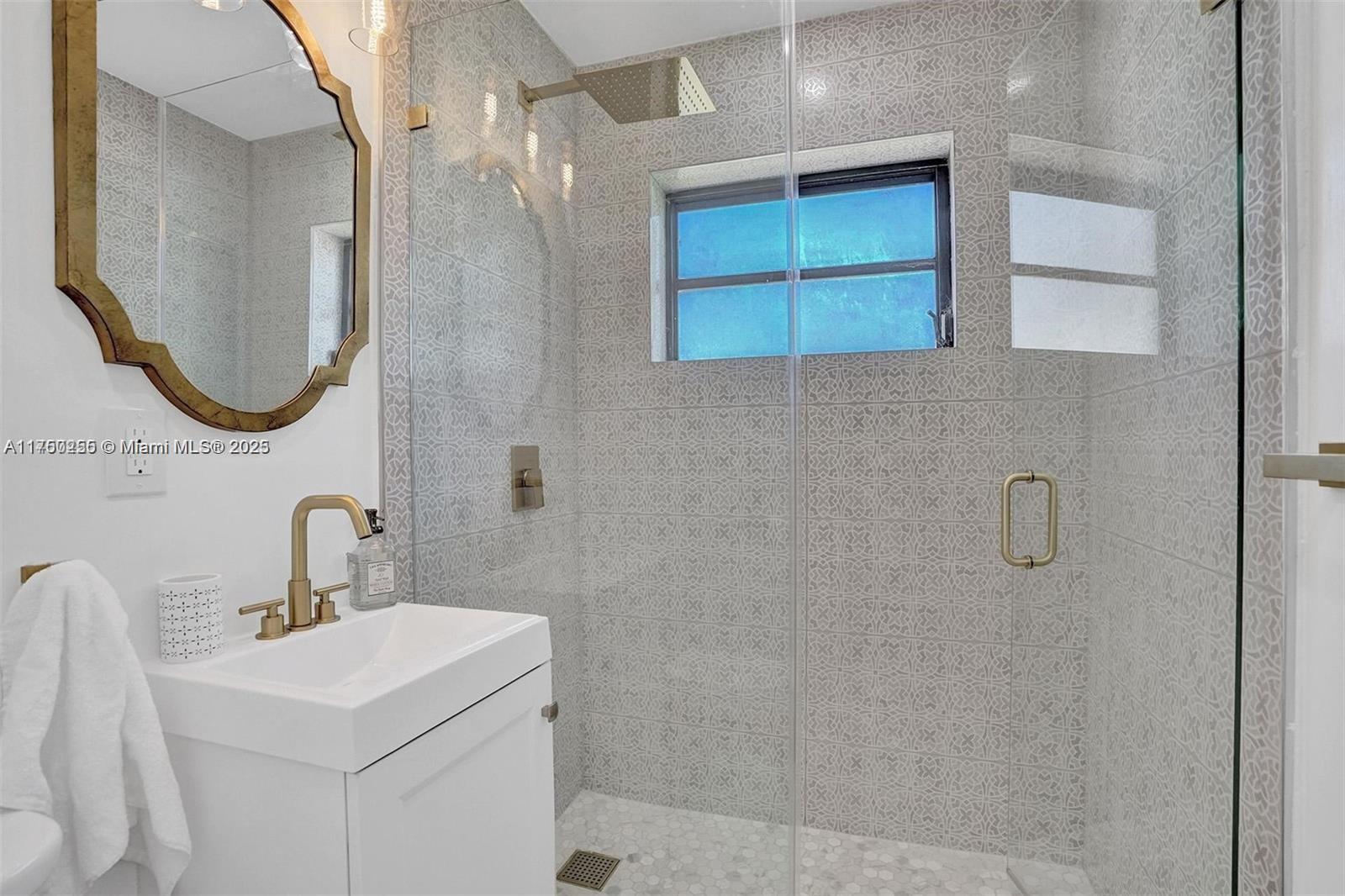 110 Southwest 5th Street Hallandale Beach, FL 33009 - Photo 25 of 26 a bathroom with a sink a mirror and shower