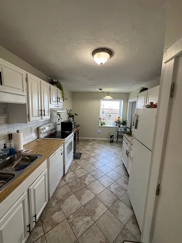 a large kitchen with a stove a refrigerator and a sink