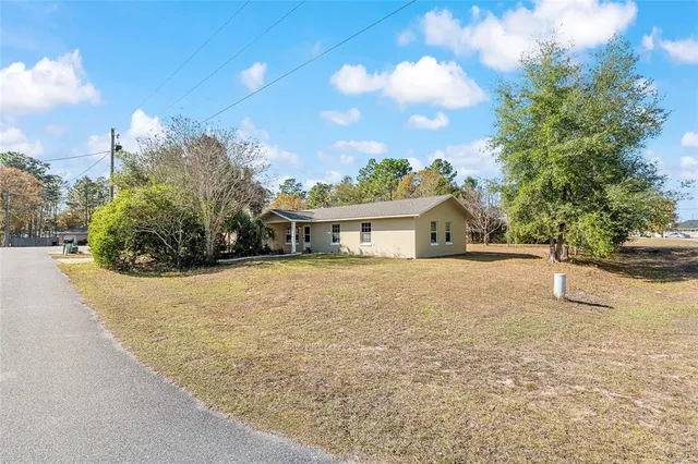 a front view of a house with a yard and trees