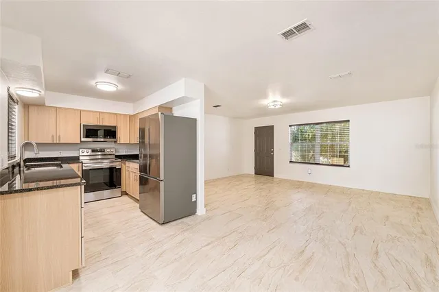 a kitchen with a refrigerator and a stove top oven