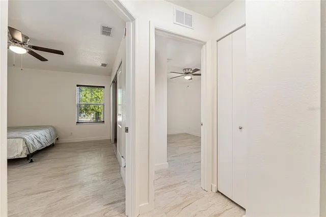 an empty room with a window and ceiling fan