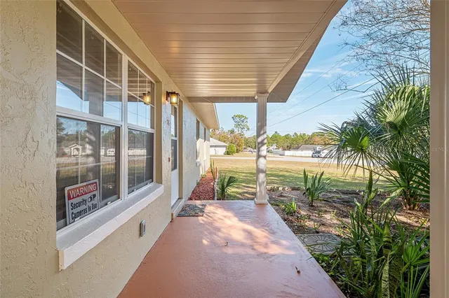 a porch with a table and chairs and potted plants