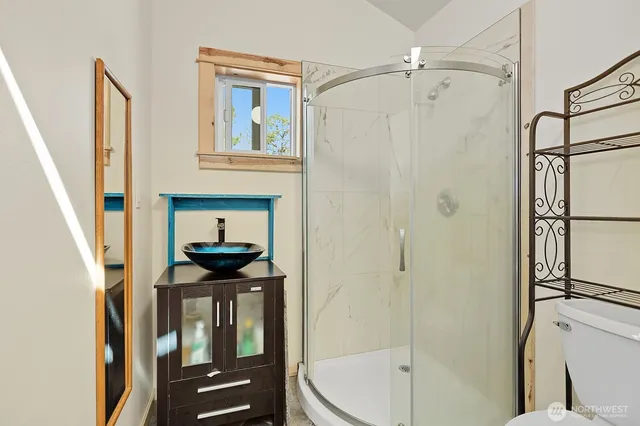 a bathroom with a sink a mirror a vanity and a shower