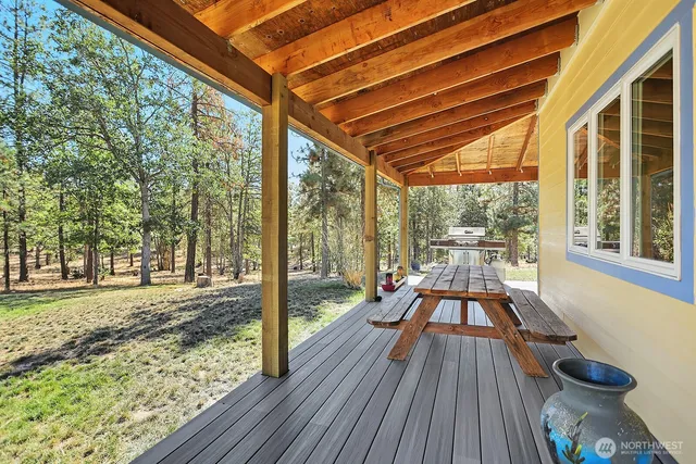 a view of a patio with table and chairs with wooden floor and fence
