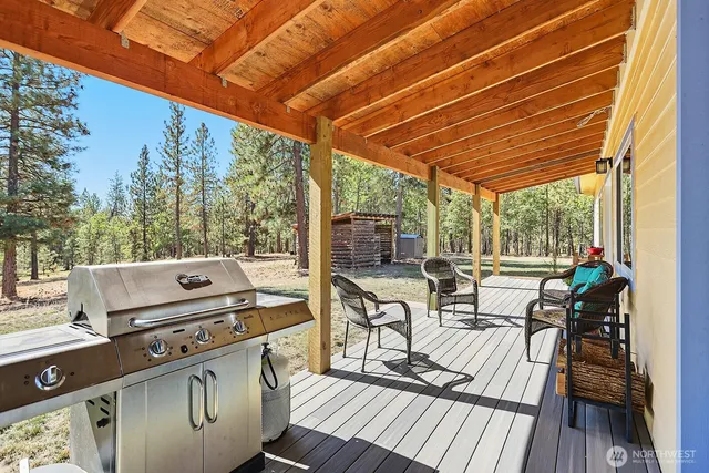 a view of a patio with dining table and chairs with wooden floor and fence