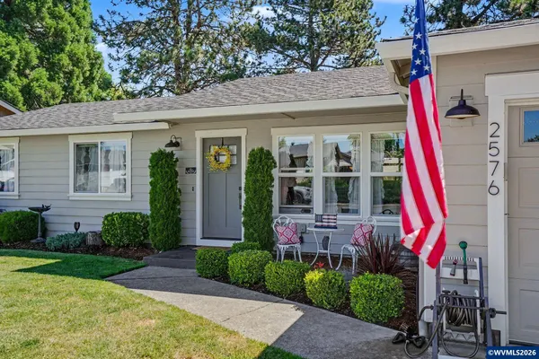 a front view of a house with a yard and potted plants