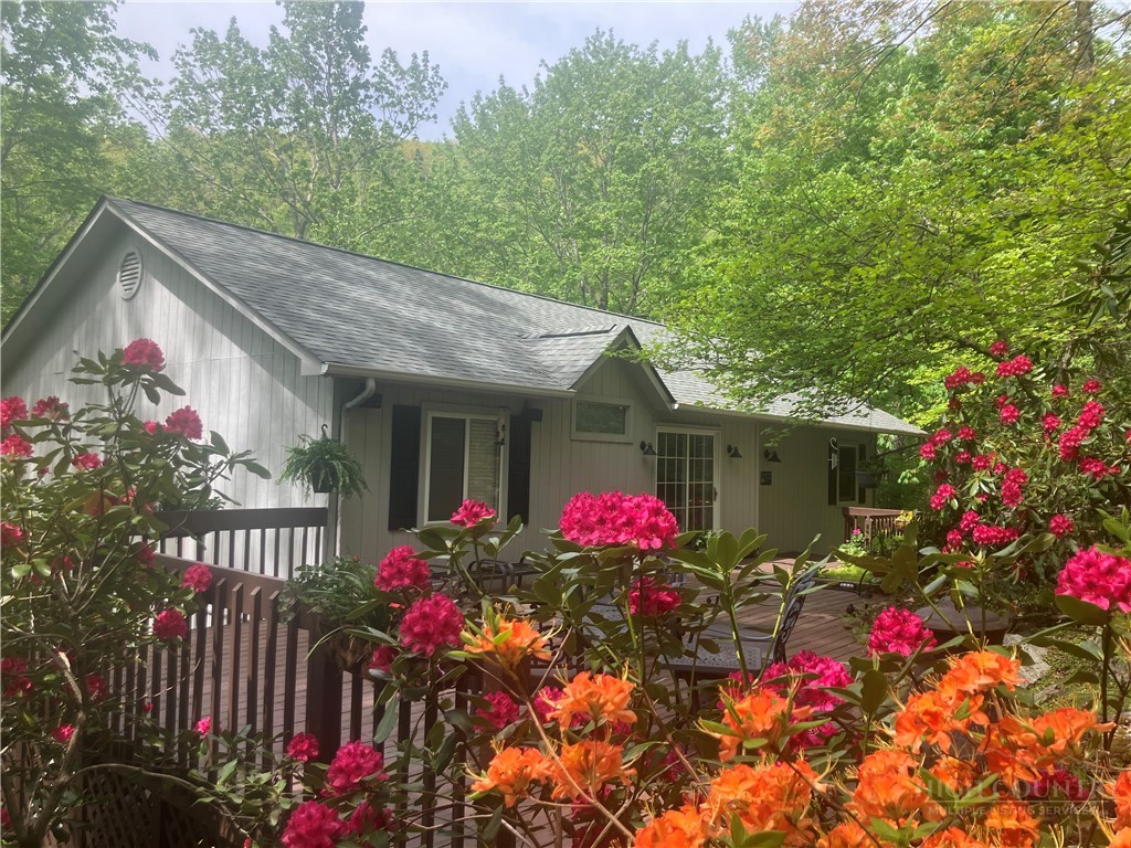220 Woodwinds Lane Seven Devils, NC 28604 - Photo 6 of 48 a view of a house with a flower garden