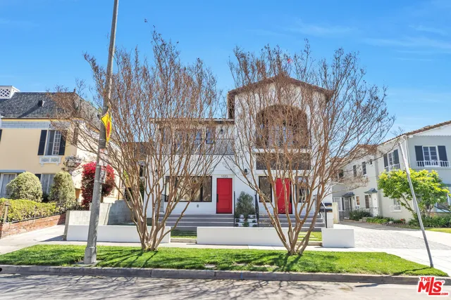 a multi story building with trees in front of it