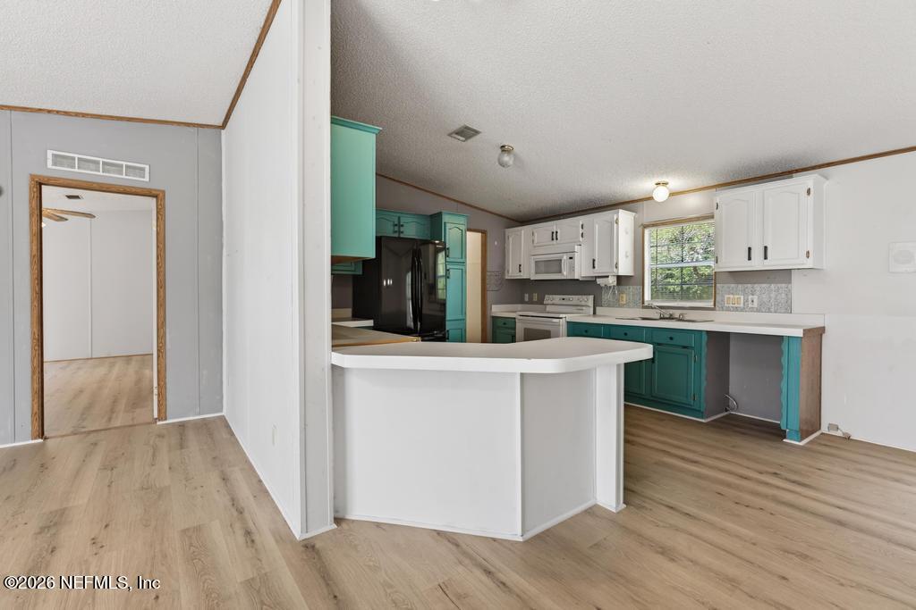 54059 Charles Street Callahan, FL 32011 - Photo 12 of 50 a kitchen with stainless steel appliances a refrigerator and a stove top oven