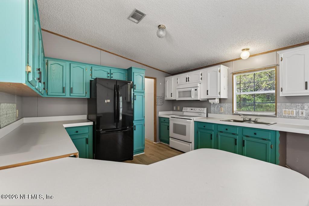 54059 Charles Street Callahan, FL 32011 - Photo 13 of 50 a kitchen with a refrigerator and a sink