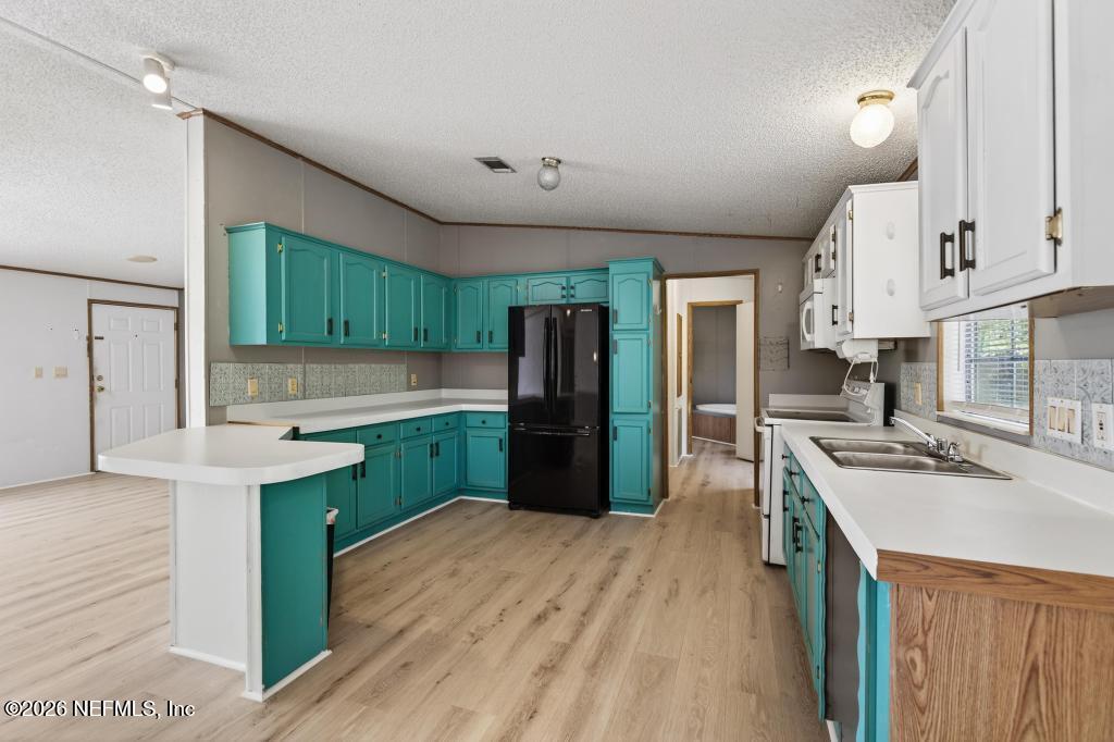 54059 Charles Street Callahan, FL 32011 - Photo 15 of 50 a kitchen with granite countertop a sink stove and refrigerator