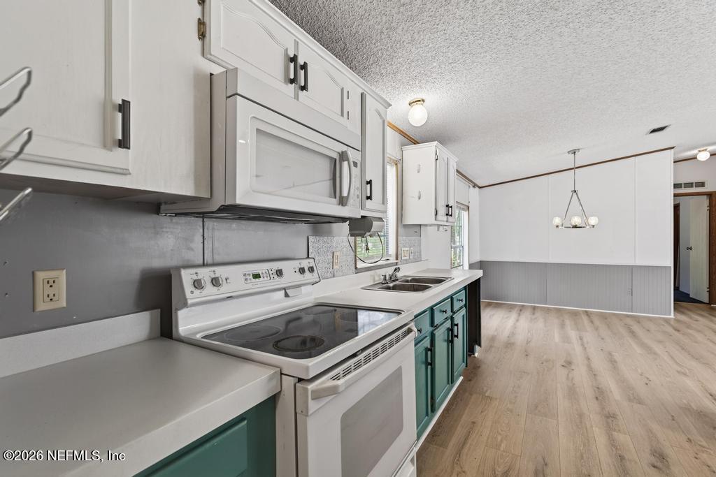 54059 Charles Street Callahan, FL 32011 - Photo 19 of 50 a kitchen with a sink a stove and cabinets
