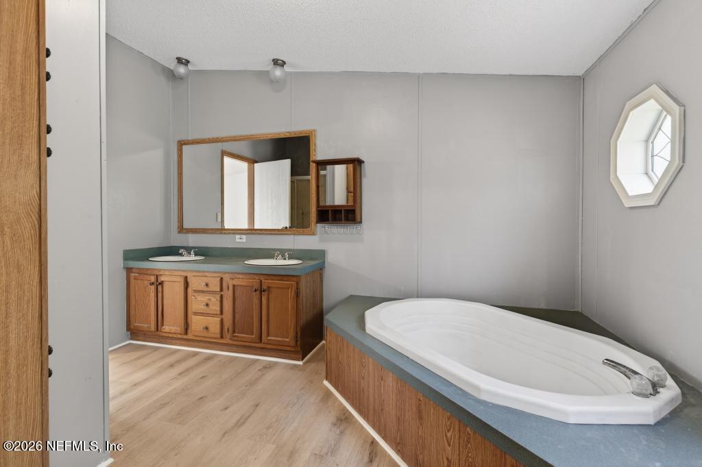 54059 Charles Street Callahan, FL 32011 - Photo 34 of 50 a bathroom with a granite countertop sink mirror vanity and toilet