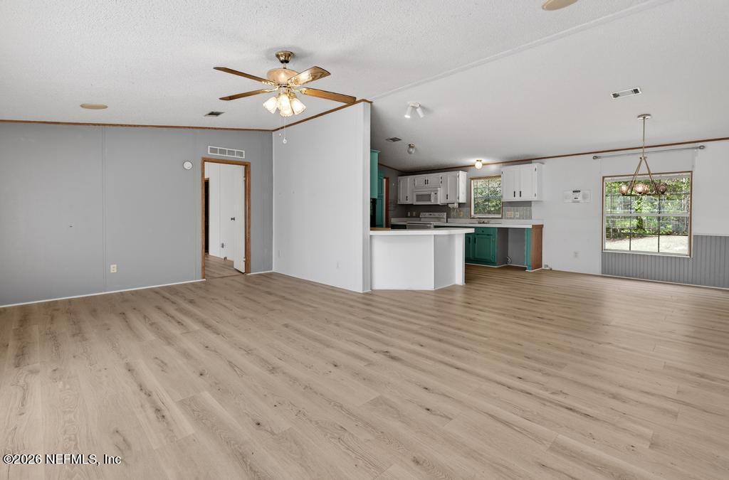 54059 Charles Street Callahan, FL 32011 - Photo 8 of 50 a open kitchen with kitchen island a refrigerator stove a sink and dishwasher with wooden floor