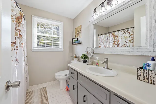 a bathroom with a sink a toilet and a window