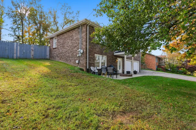 a view of a backyard with large trees and a barn with large trees