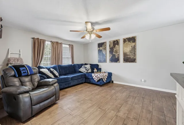 a living room with furniture and a ceiling fan