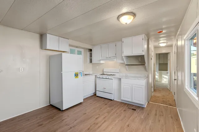 a kitchen with white cabinets and white appliances