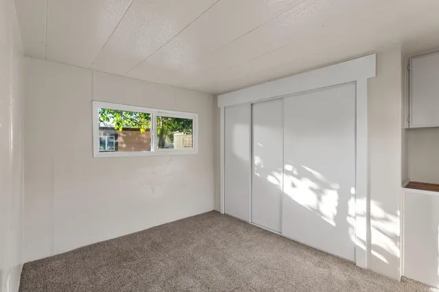 a view of a big room with windows and chandelier fan