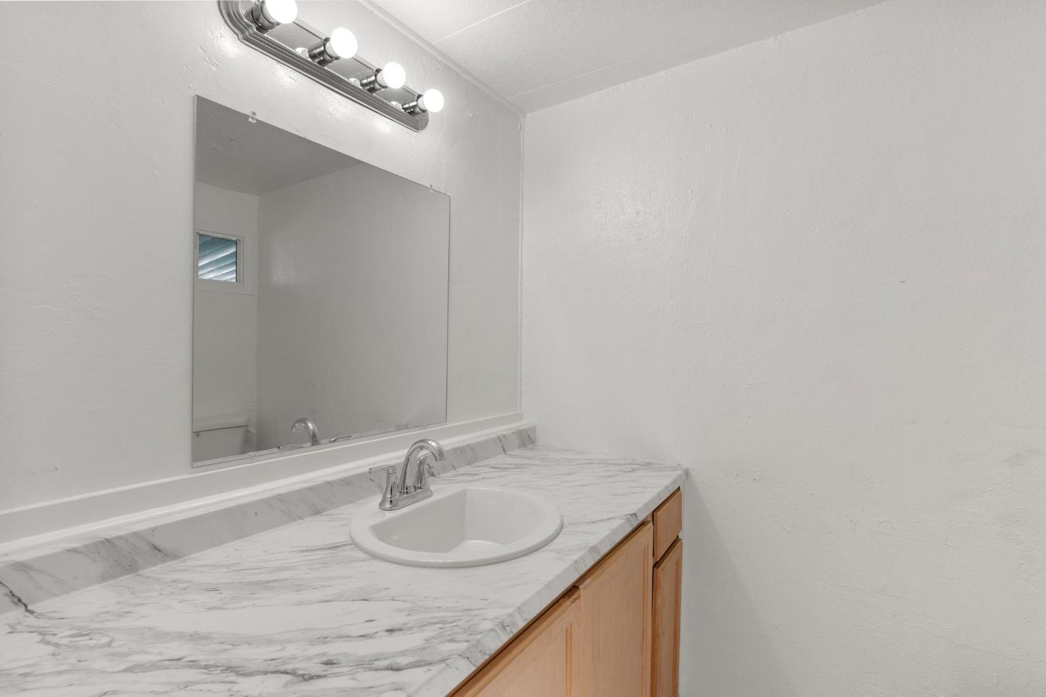1523 North Beale Road, Unit 38 Marysville, CA 95901 - Photo 24 of 24 a bathroom with a granite countertop sink and a mirror