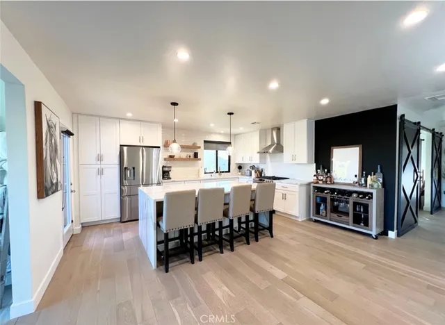 a large white kitchen with stainless steel appliances