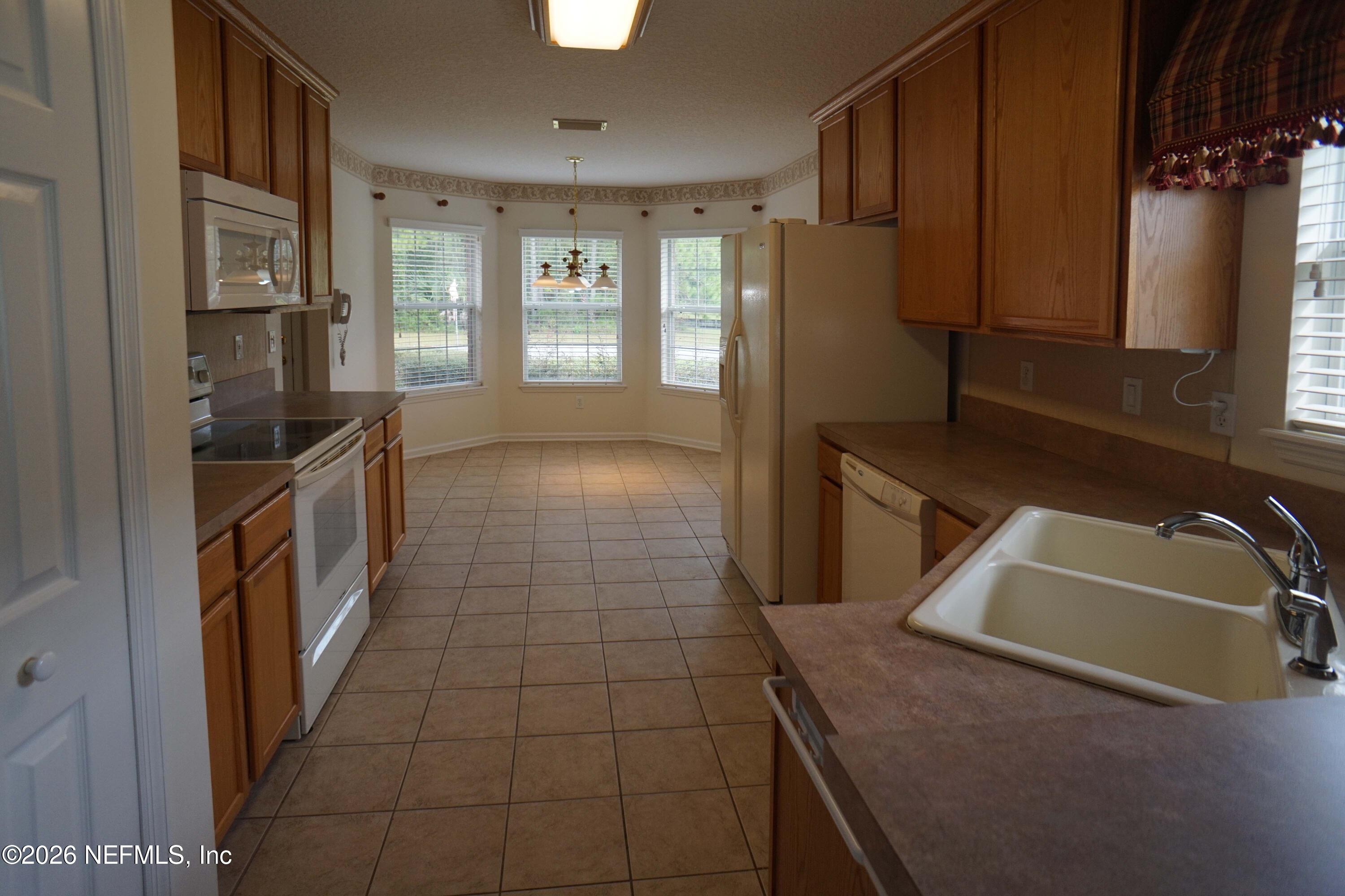 1721 Keswick Road St. Augustine, FL 32084 - Photo 4 of 17 a kitchen with granite countertop a sink a stove and a refrigerator